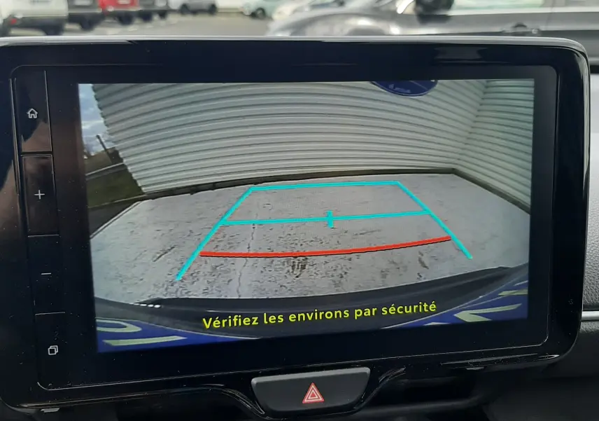 Écran de caméra de recul dans une Toyota Yaris Cross 2024, affichant les lignes de guidage en bleu et rouge.