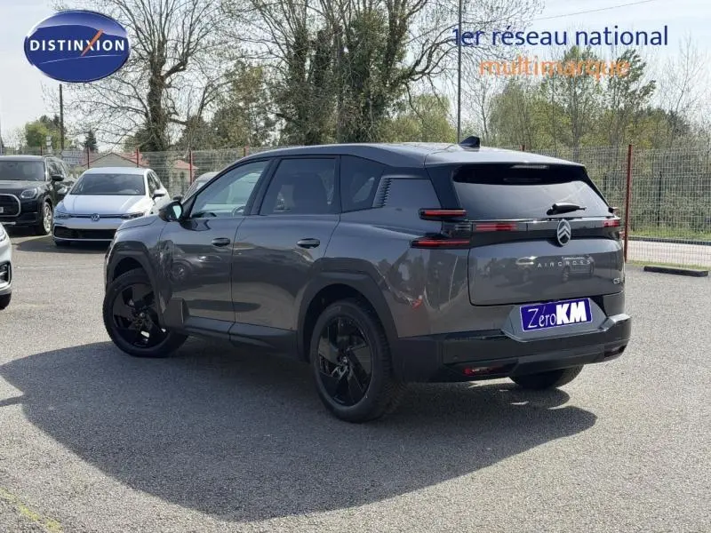 Vue 3/4 arrière droite d'un Citroën C5 Aircross gris Platinium avec jantes noires et vitres teintées.