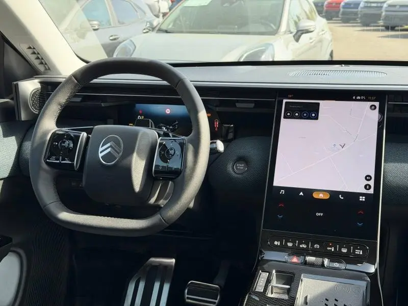 Vue intérieure du tableau de bord et volant noir du Citroën C5 Aircross gris avec écran tactile vertical et démarrage sans clé.