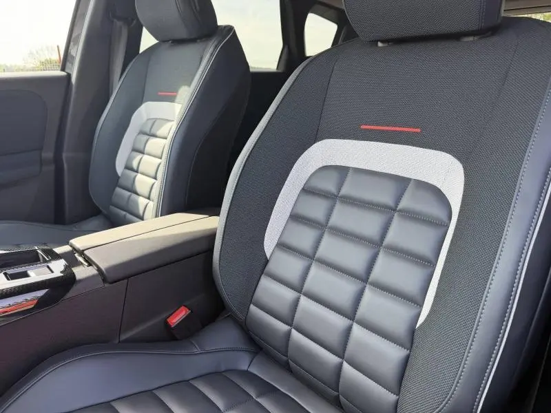 Gros plan sur les sièges avant en cuir noir et tissu gris avec surpiqûres rouges du Citroën C5 Aircross 2026.