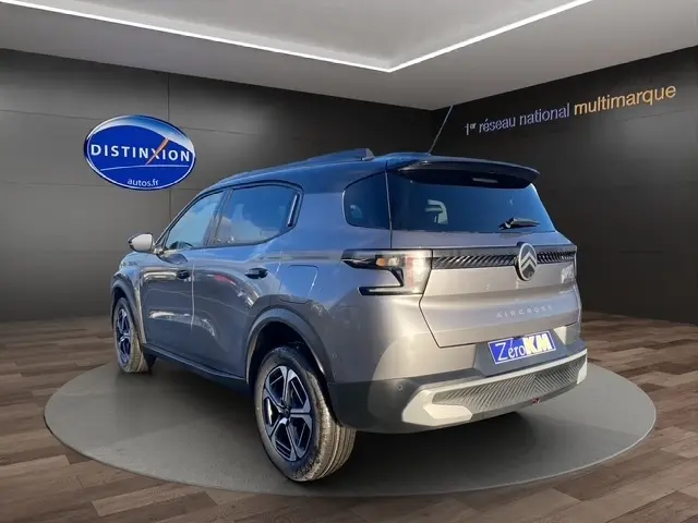 Vue 3/4 arrière droite d'un Citroën C3 gris foncé avec toit noir et jantes alliage distinctives.