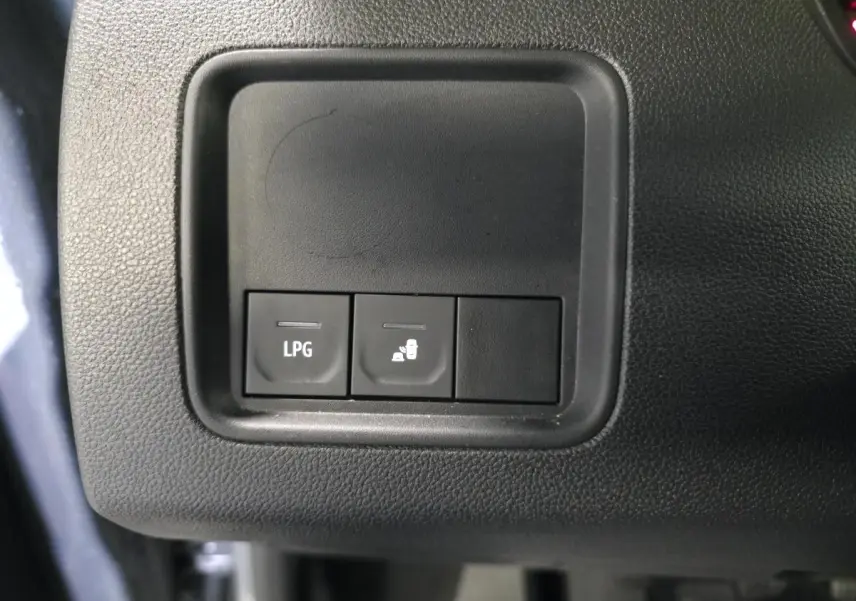 Gros plan sur les boutons de commande LPG et verrouillage de la trappe à carburant du Dacia Duster gris.