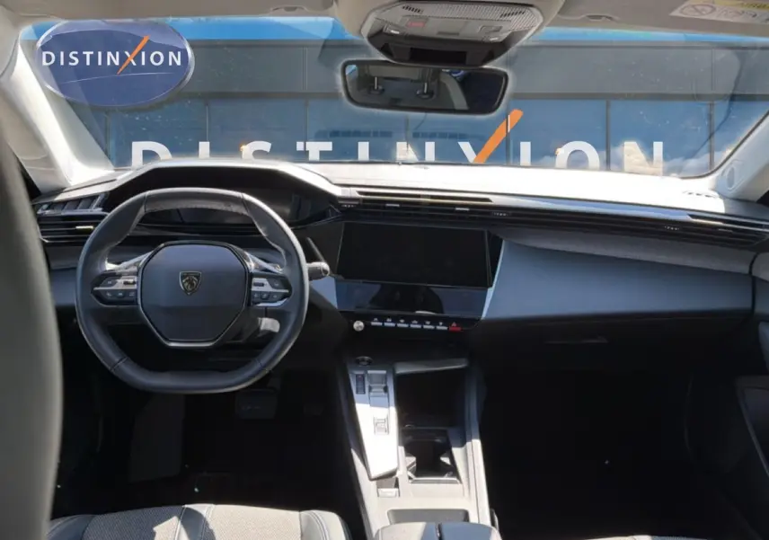 Vue intérieure avant du Peugeot 408 Hybrid 145 allure avec tableau de bord moderne et volant compact noir.