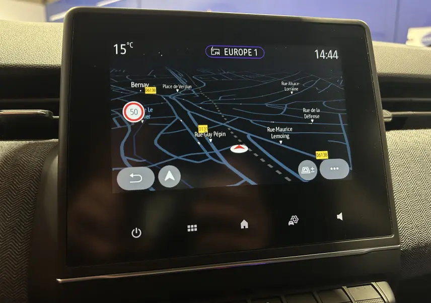 Écran tactile du GPS de la Renault Clio V E-Tech en gros plan, affichant une carte de navigation nocturne.