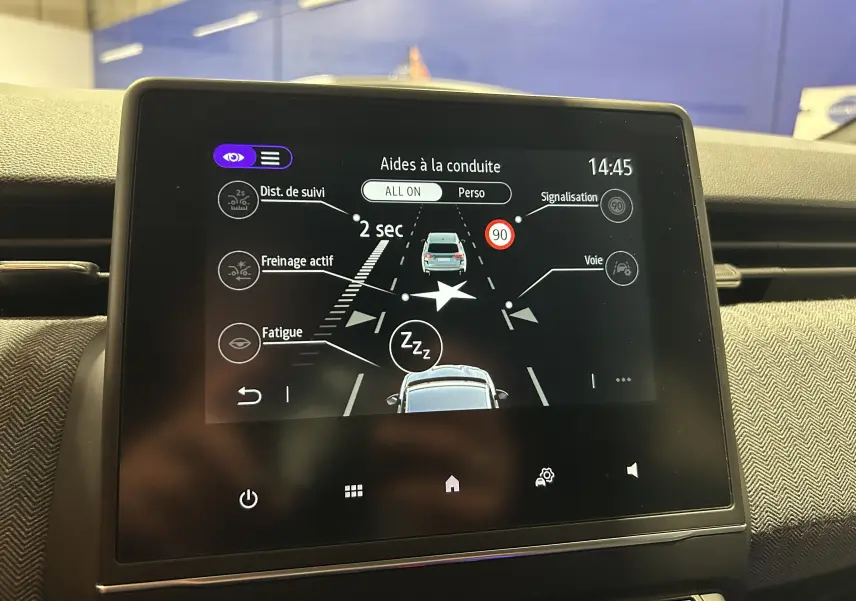 Écran tactile intérieur de la Renault Clio V gris Rafale montrant les aides à la conduite en fonctionnement.