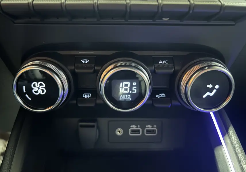 Gros plan sur les commandes de climatisation digitale à 18,5°C et ports USB de la Renault Clio V gris Rafale.