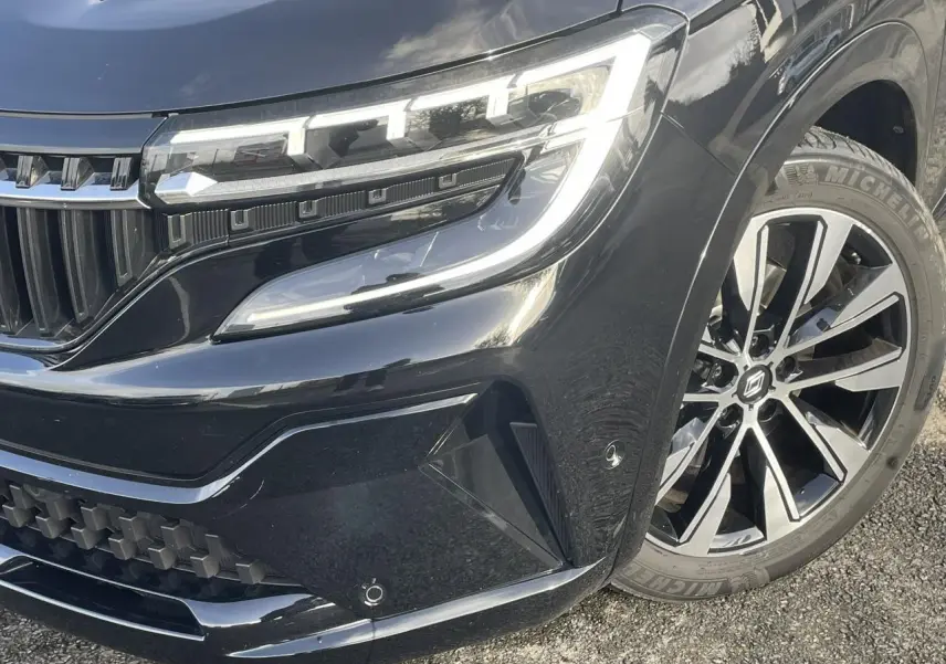 Gros plan sur l'avant droit du Renault Espace noir étoilé, mettant en valeur le phare LED et la jante alliage 19 pouces.