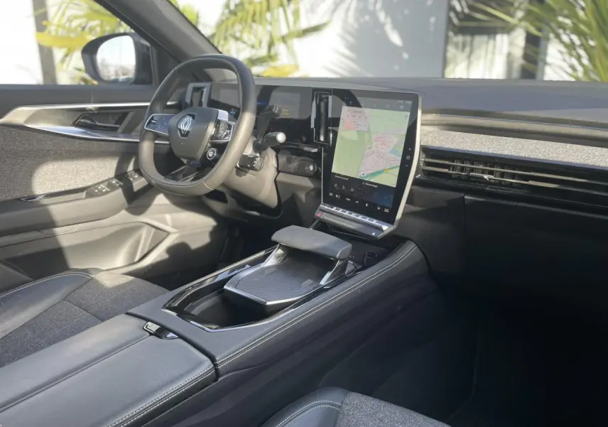 Vue intérieure côté conducteur du Renault Espace 2024, avec volant multifonction, écran tactile vertical et sellerie grise.