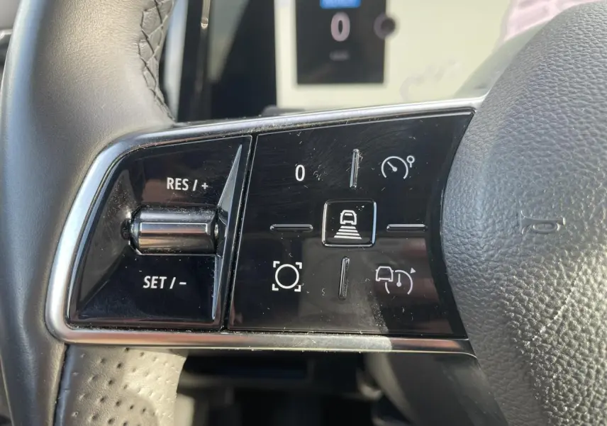 Gros plan sur les commandes de régulateur de vitesse au volant noir du Renault Espace 2024 E-Tech Full Hybrid.