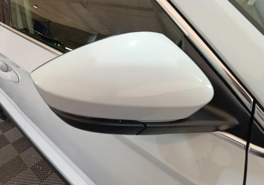 Rétroviseur droit blanc du Skoda Karoq 2.0 TDI 2024, vue rapprochée sur la portière et poignée.