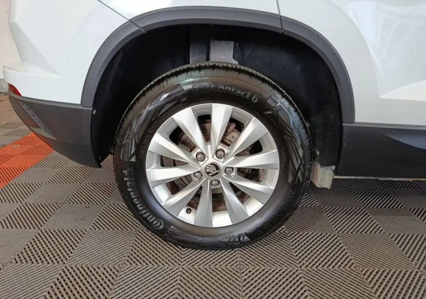 Gros plan sur la roue arrière droite d’un Skoda Karoq blanc 2024, avec jante alliage et pneu Continental.
