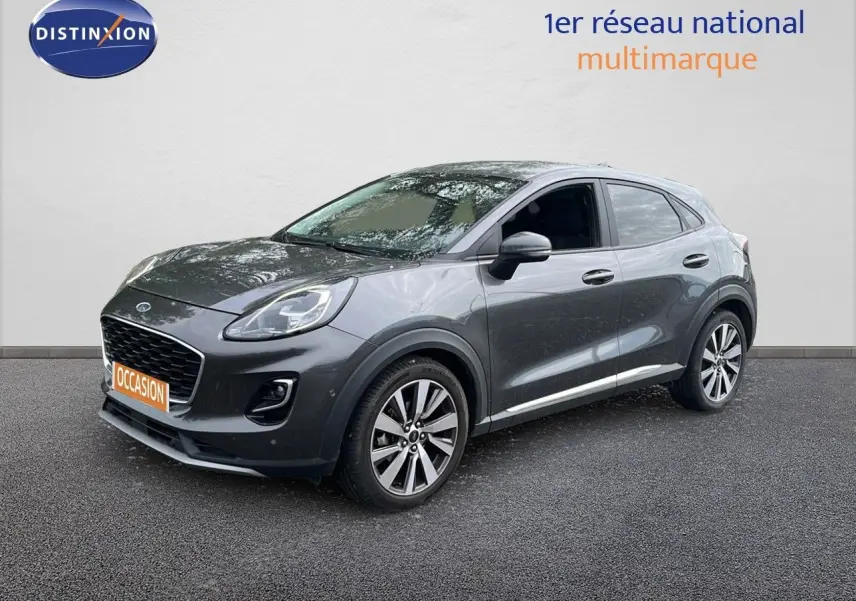 Ford Puma gris 3/4 avant droit, SUV compact avec jantes alliage et calandre noire distinctive.