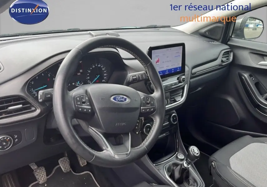 Vue intérieure côté conducteur du Ford Puma gris 2021, mettant en valeur le volant multifonction et la console centrale avec écran tactile.