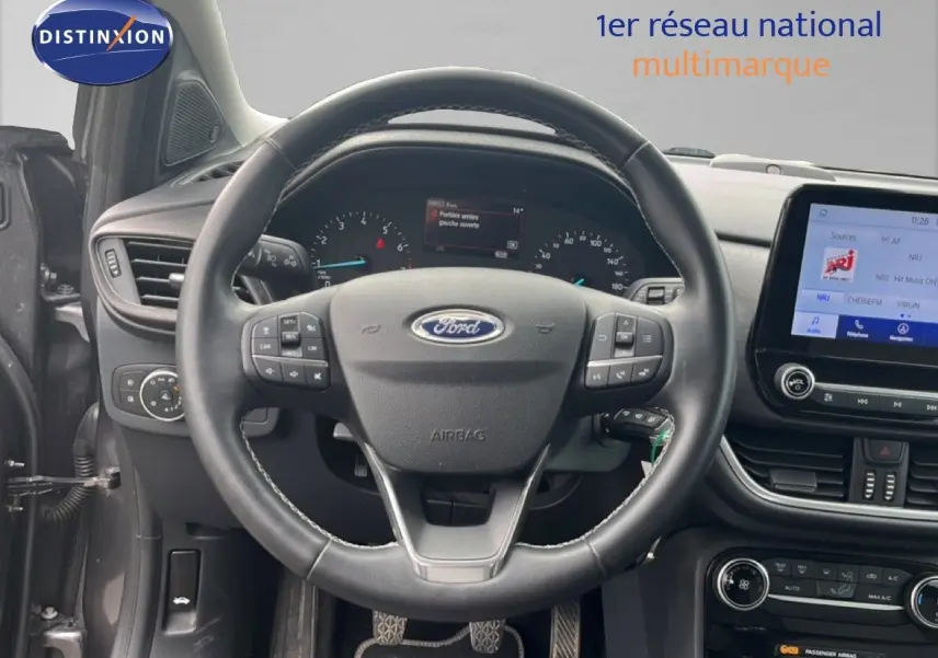 Vue intérieure centrée sur le volant du Ford Puma gris 2021, avec tableau de bord et écran tactile visibles.