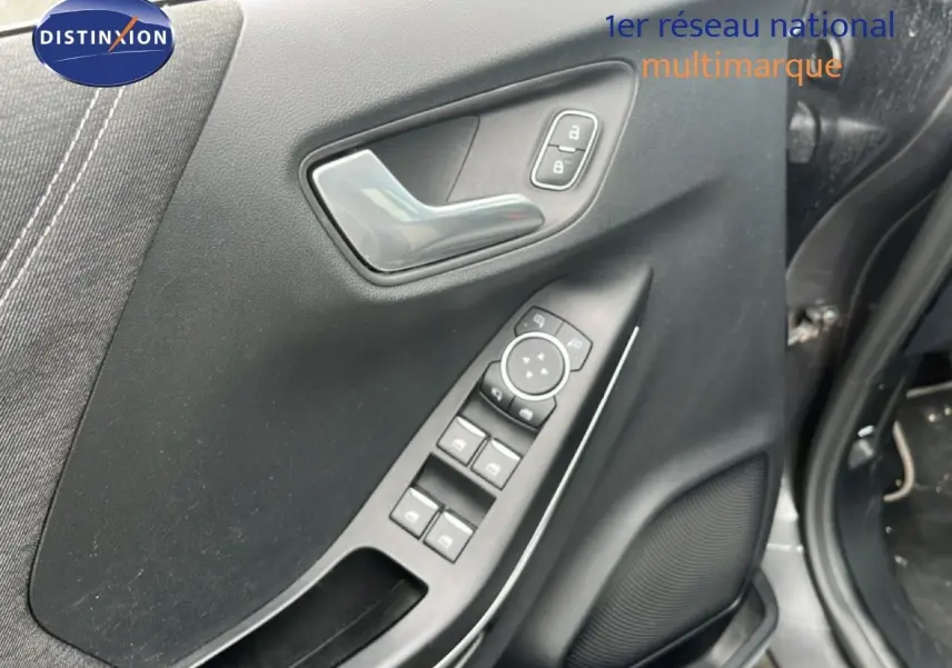 Vue rapprochée de la porte avant gauche grise du Ford Puma 2021 avec commandes électriques et poignée chrome.
