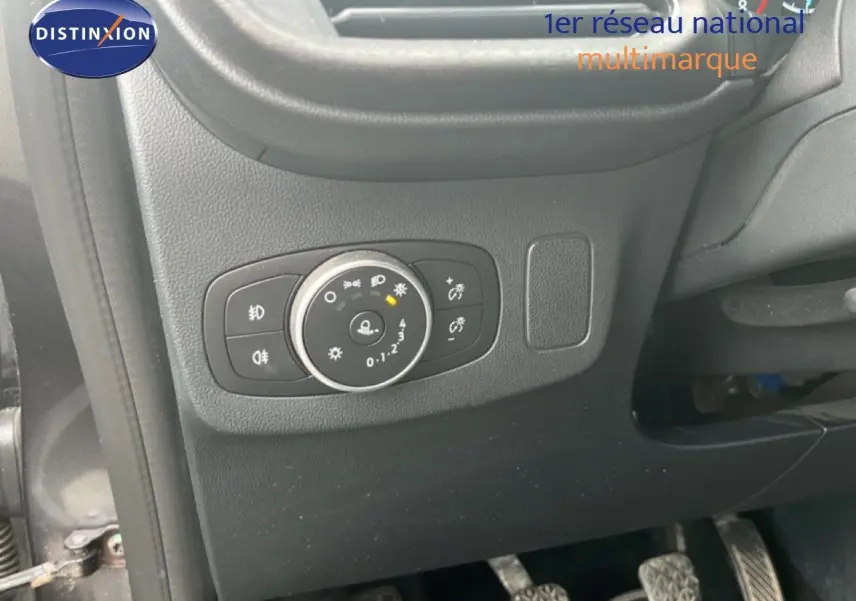 Détail du tableau de bord côté gauche du Ford Puma gris 2021, montrant la commande des phares et les pédales.
