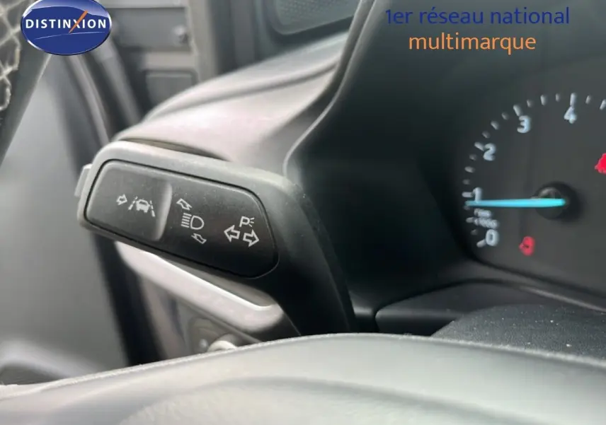 Gros plan sur le commodo gauche du tableau de bord du Ford Puma gris 2021, montrant les commandes d’éclairage et d’aide à la conduite.