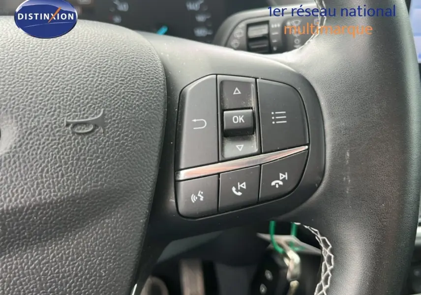 Gros plan sur les commandes multifonctions du volant noir du Ford Puma gris 2021, version 1.0 EcoBoost Titanium.