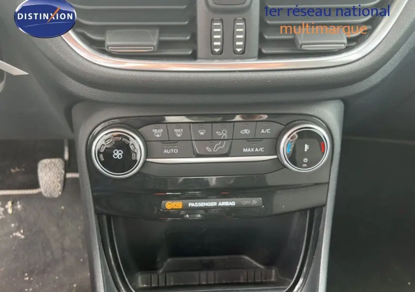 Vue rapprochée du tableau de bord central de la Ford Puma gris 2021, montrant les commandes de climatisation et ventilation.
