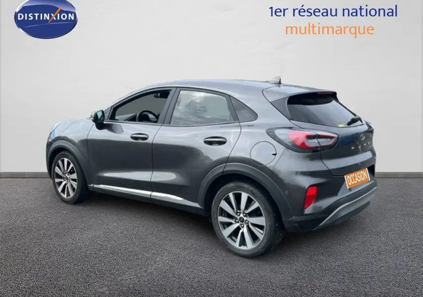 Ford Puma gris en 3/4 arrière côté gauche, mettant en valeur ses lignes fluides et ses jantes alliage.