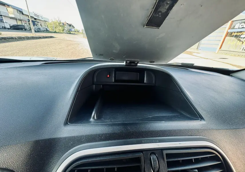 Vue intérieure du tableau de bord noir du Renault Kangoo Maxi 2021 avec compartiment ouvert sous le pare-brise.