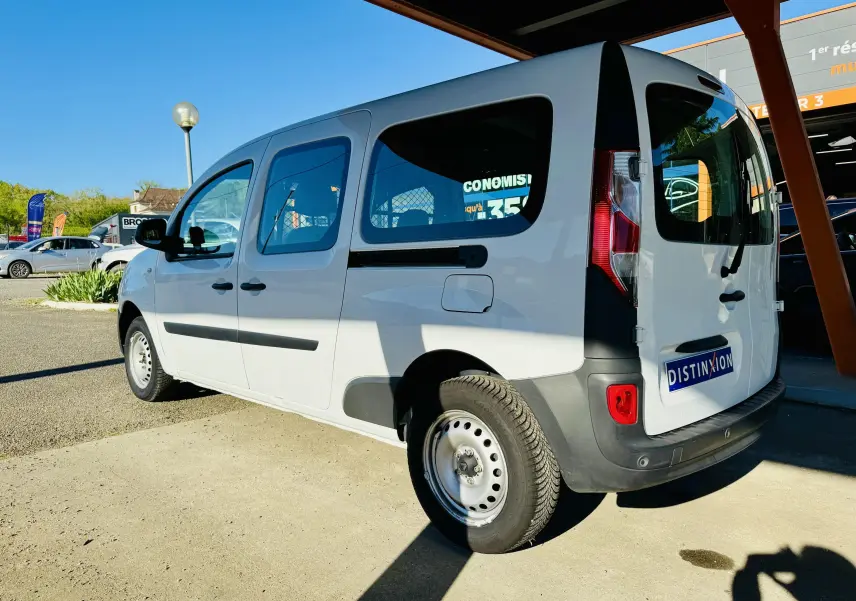 Vue 3/4 arrière droite d’un Renault Kangoo Maxi blanc avec vitres teintées et pare-chocs noirs, stationné en extérieur.