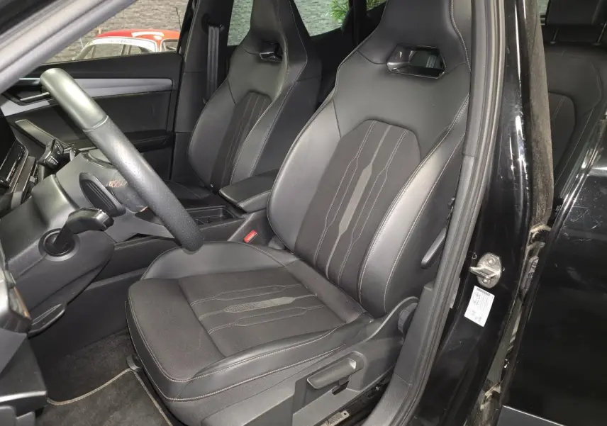 Intérieur côté conducteur du CUPRA Formentor noir, sièges baquets en textile avec surpiqûres cuivre visibles.