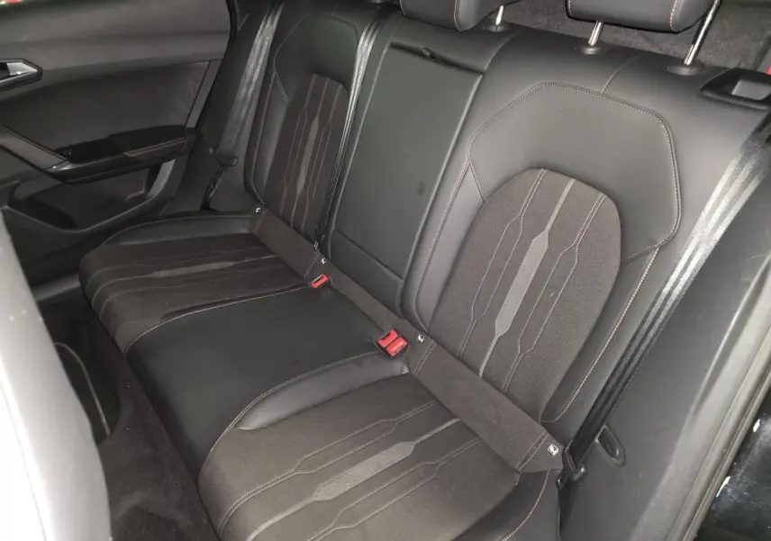 Vue intérieure côté arrière droit des sièges baquets noirs en textile du CUPRA Formentor 1.4 e-Hybrid 2023 avec surpiqûres cuivre.