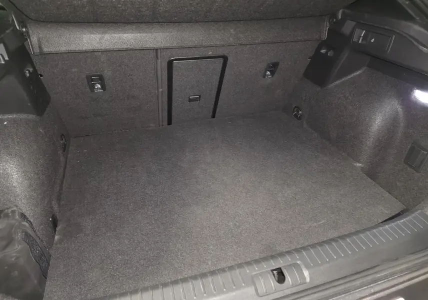 Coffre spacieux de la CUPRA Formentor noir, vue intérieure arrière avec éclairage et finitions en tissu gris.
