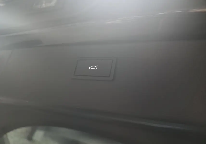 Bouton d'ouverture électrique du hayon sur la partie intérieure noire du coffre d'un CUPRA Formentor noir.