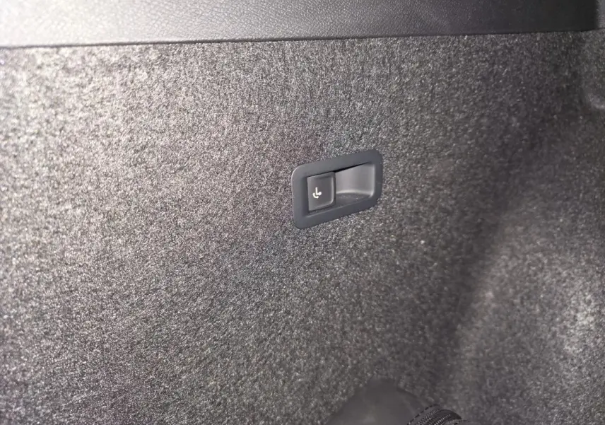 Détail du bouton de rabattement électrique des sièges arrière dans le coffre du CUPRA Formentor noir 2023.