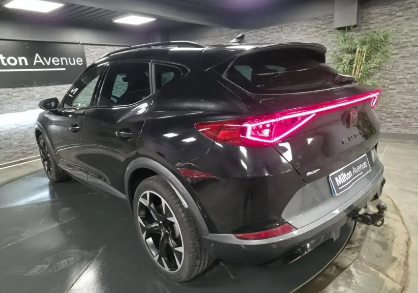 Vue 3/4 arrière droite du CUPRA Formentor noir avec feux arrière LED en bandeau et crochet d'attelage escamotable.