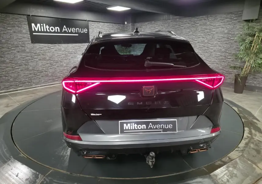Vue arrière d'un CUPRA Formentor noir avec feux LED en bandeau et crochet d'attelage escamotable visible.