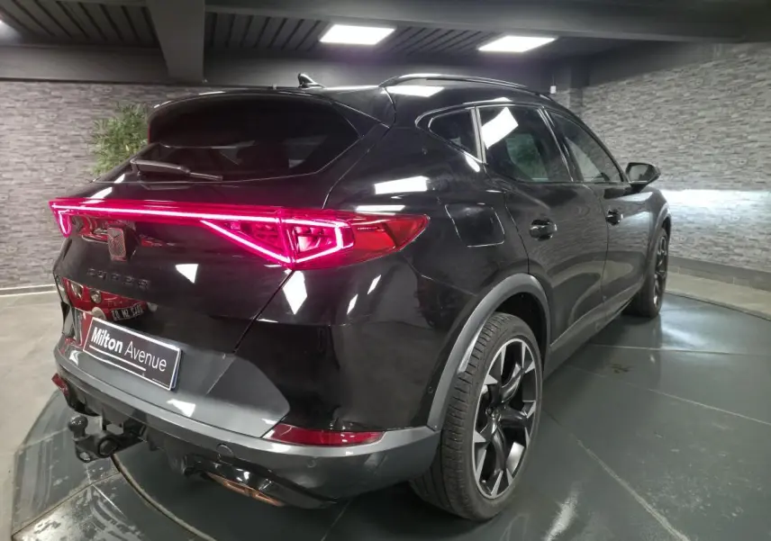 Vue 3/4 arrière droite du CUPRA Formentor noir avec feux arrière LED en bandeau et crochet d'attelage escamotable.