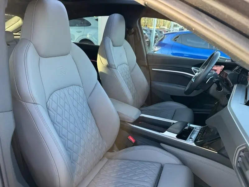 Vue intérieure côté conducteur de l'Audi E-Tron Sportback 50 S Line 2020 avec sièges sport gris clair et volant cuir noir.