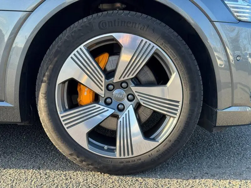Gros plan sur la roue avant droite gris foncé métal de l'Audi E-Tron Sportback avec étrier de frein orange distinctif.