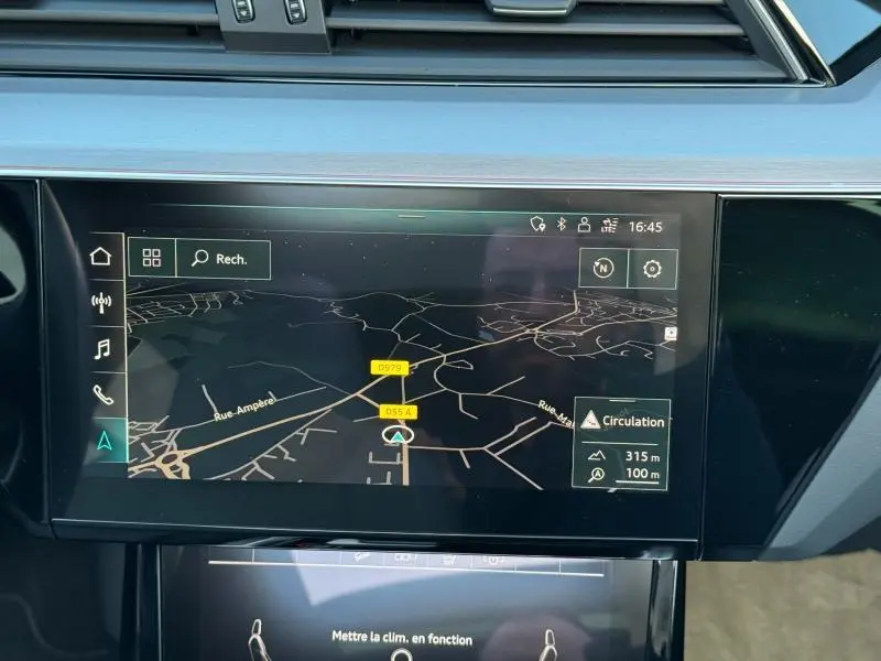 Écran tactile central affichant la navigation GPS dans l’Audi E-Tron Sportback gris foncé, vue intérieure frontale.