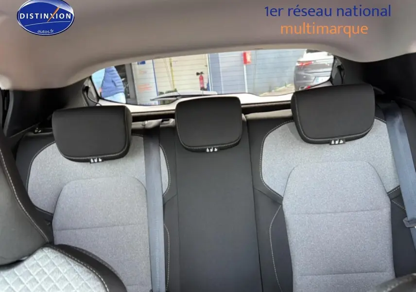 Vue arrière intérieure de la banquette arrière grise à motifs 3D du Renault Clio V 2025 avec appuie-têtes noirs.