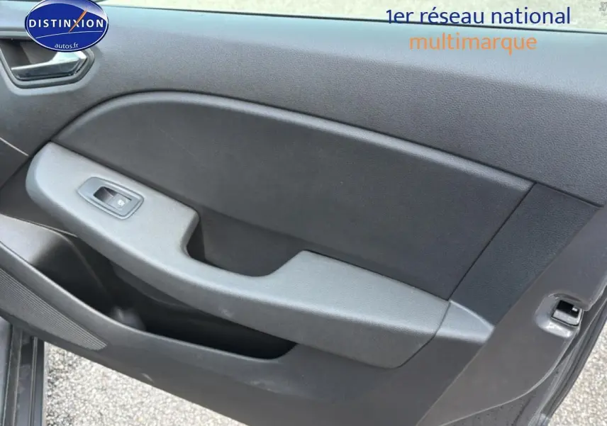 Détail de la porte côté gauche de la Renault Clio V gris, montrant la commande de vitre électrique et le revêtement intérieur noir.