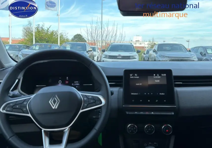 Vue intérieure avant du tableau de bord gris et noir de la Renault Clio V avec écran tactile et volant multifonction.