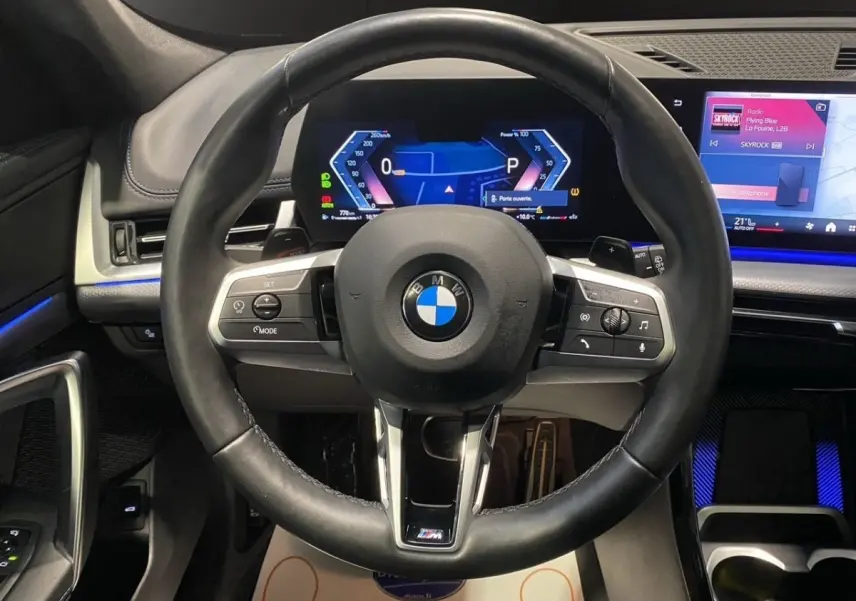Vue frontale du volant cuir noir et du tableau de bord numérique lumineux du BMW X1 xDrive20d M Sport PRO 2025.