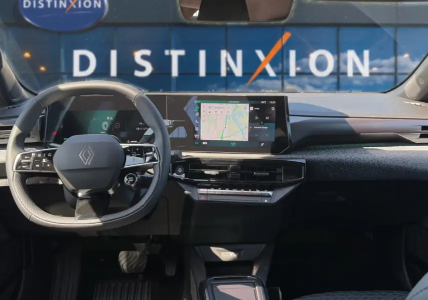 Vue intérieure avant de la Renault Clio VI noire, avec volant multifonctions et écran tactile central affichant la navigation.