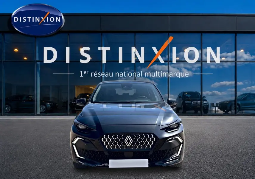 Vue avant d'une Renault Clio VI noire stationnée devant une vitrine avec logo Distinxion.