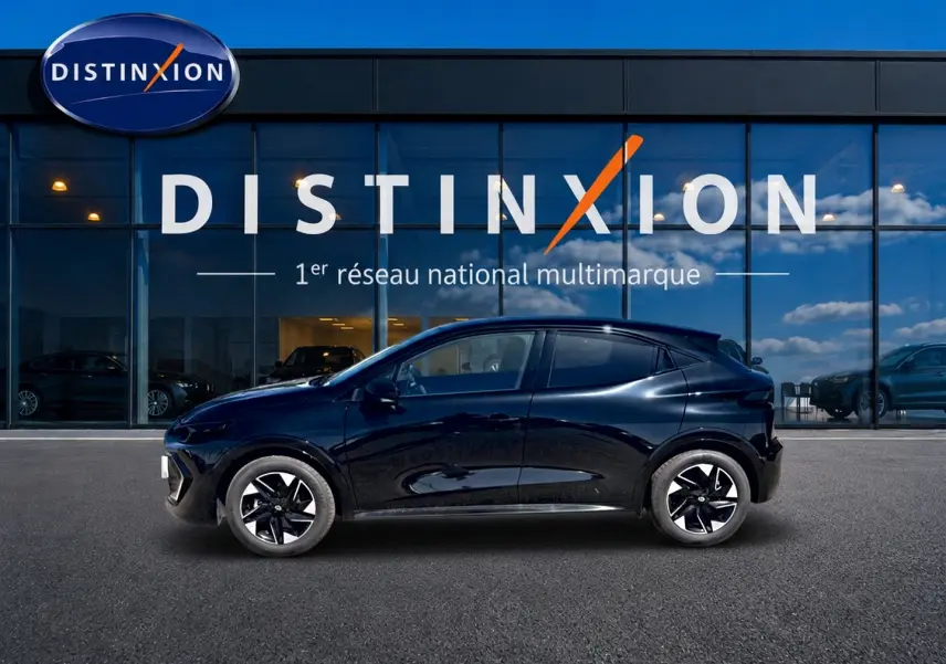 Profil côté gauche de la Renault Clio VI noire 2026, avec jantes alliage 16 pouces, devant une vitrine Distinxion.