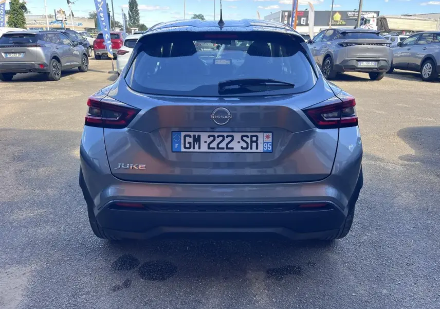 Vue arrière d'un Nissan Juke 2023 gris argile spéciale, avec feux arrière LED et plaque d'immatriculation française visible.