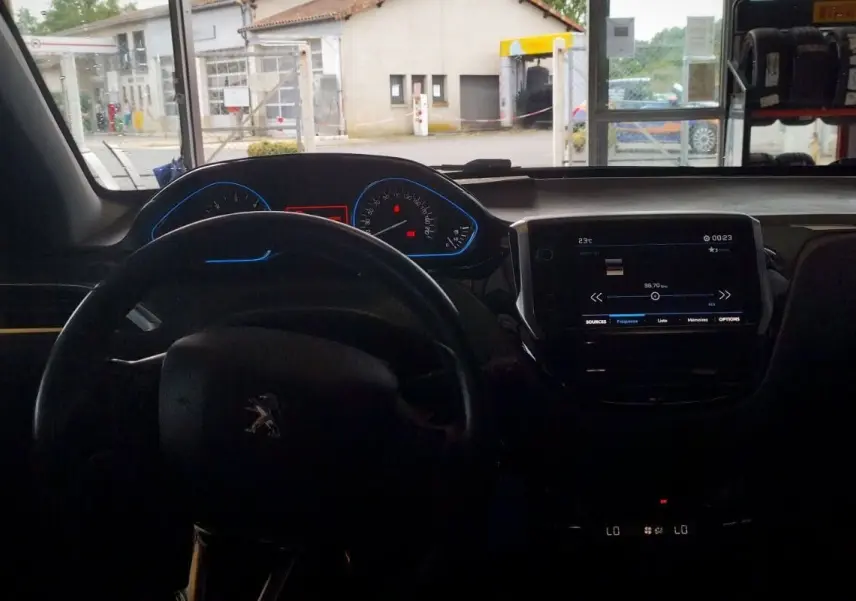 Vue intérieure du tableau de bord et volant noir d'une Citroën Berlingo 2016, avec écran tactile allumé.