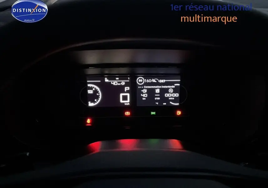 Tableau de bord numérique éclairé de nuit du Citroën Berlingo Fourgon blanc, affichant la consommation et la vitesse.