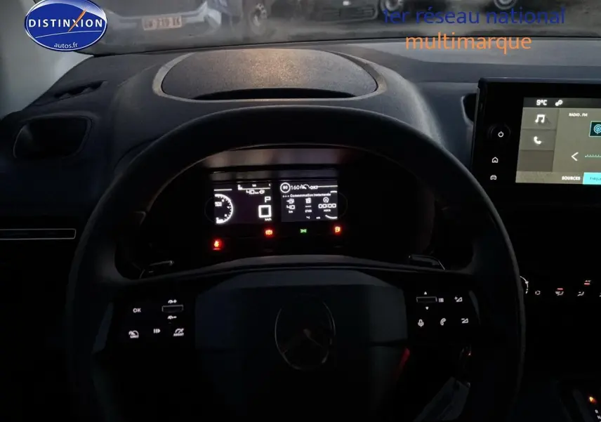 Vue intérieure centrée sur le volant multifonction et l'instrumentation digitale du Citroën Berlingo Fourgon blanc 2025.