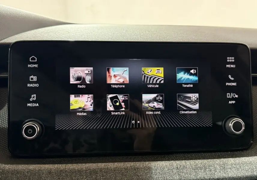 Écran tactile central du tableau de bord du Skoda Kamiq 2024 affichant les menus multimédias et aides à la conduite.