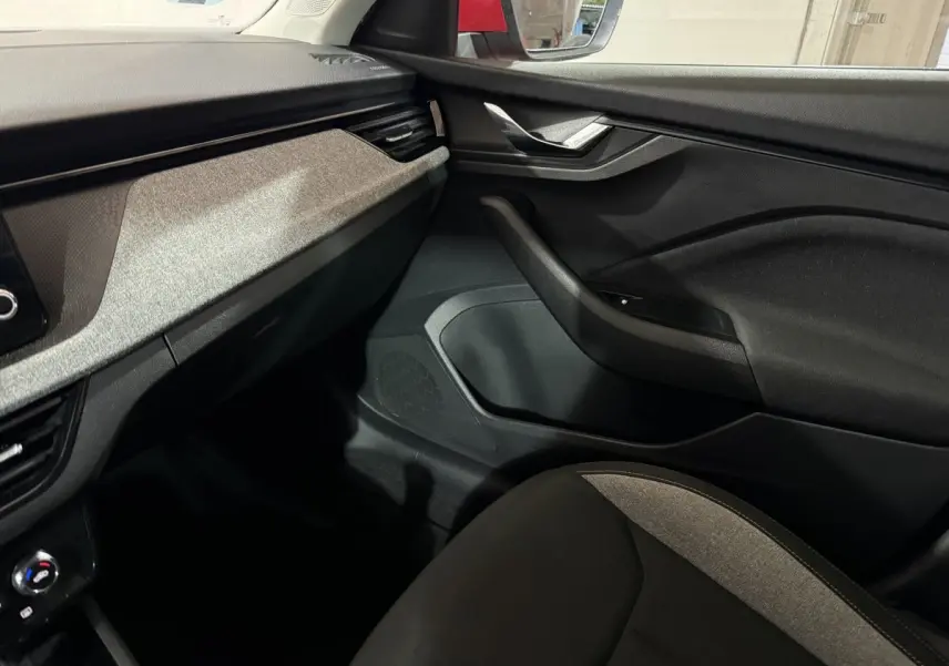 Vue intérieure côté passager du tableau de bord et porte noire avec insert gris du Skoda Kamiq 2024.